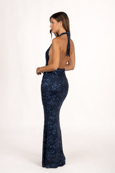 Vestido Fiori Azul con escote halter atado al cuello y espalda descubierta, un diseño sofisticado y moderno. Ideal para tu look de invitada de otoño o eventos de noche. Confeccionado en gasa ligera con lentejuelas.